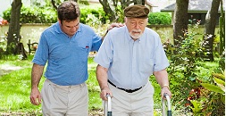 Son walking outside with his father who is using a walker